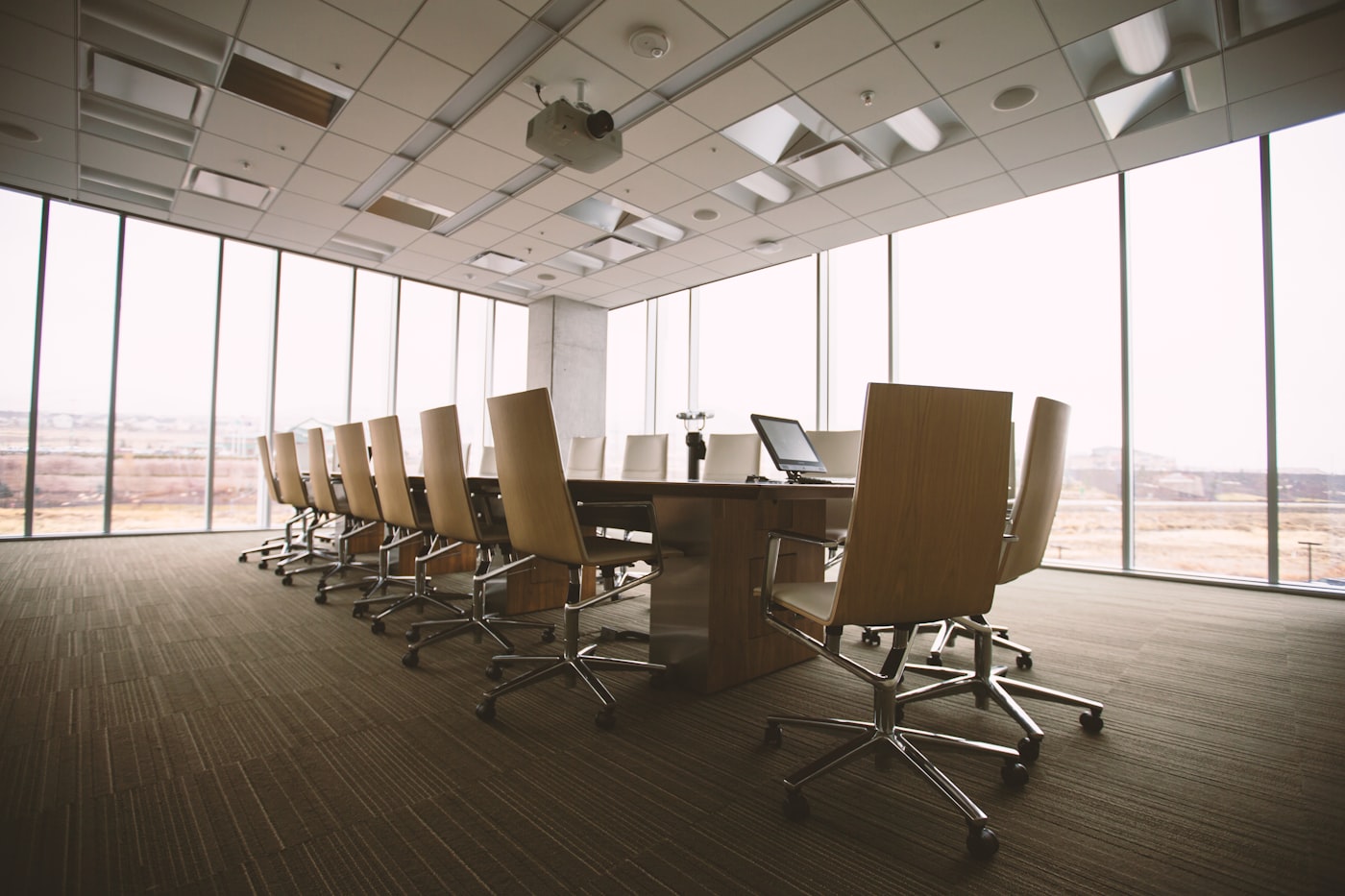 Sala de directorio corporativa con mesa de reuniones y ventanales de piso a techo
